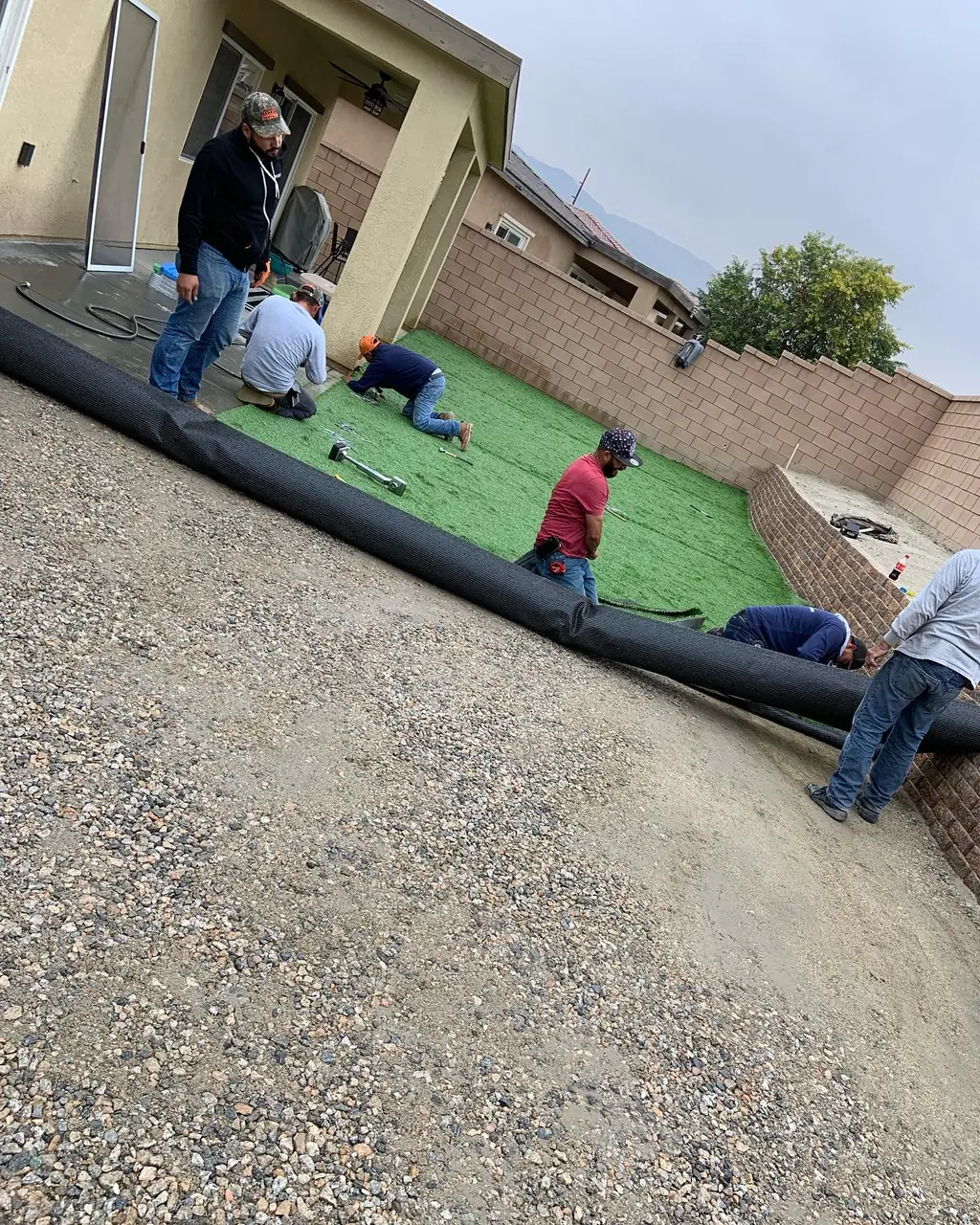 Martinez Bros crew installing artificial turf over a prepped base in a Coachella Valley backyard